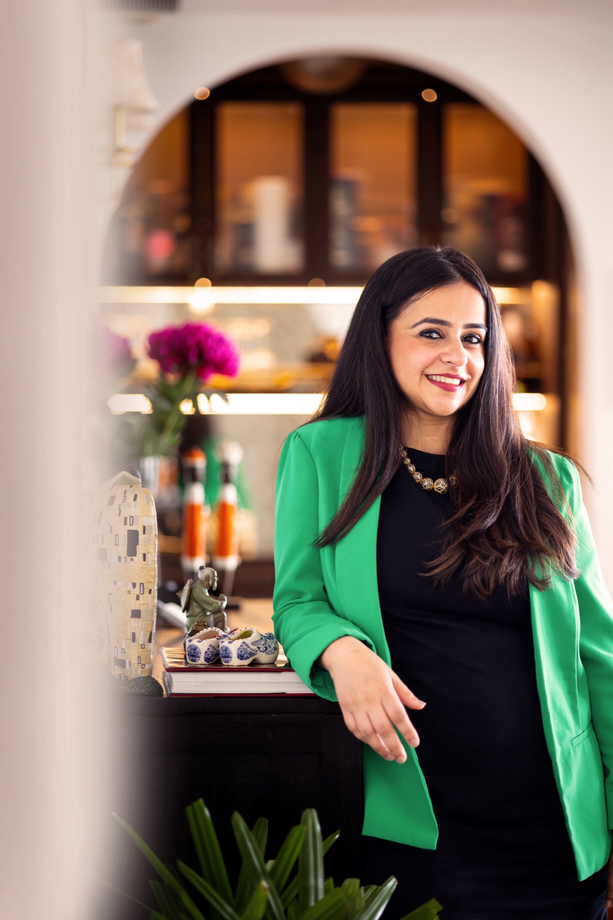 Ritika leaning against a cabinet at home